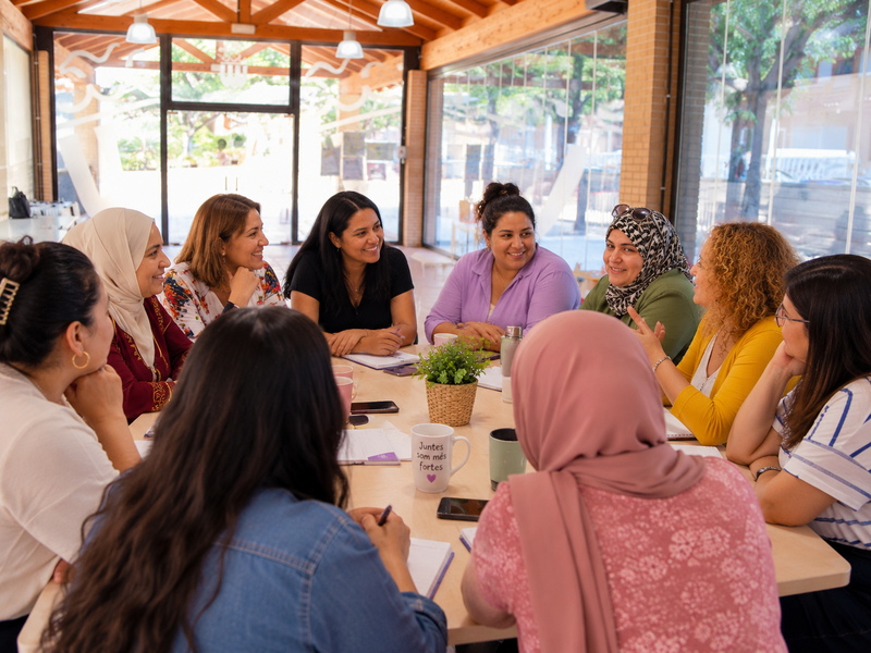 Mujeres migrantes de Paiporta reunidas alrededor de una mesa durante un encuentro de la asociación Nosotras Paiporta
